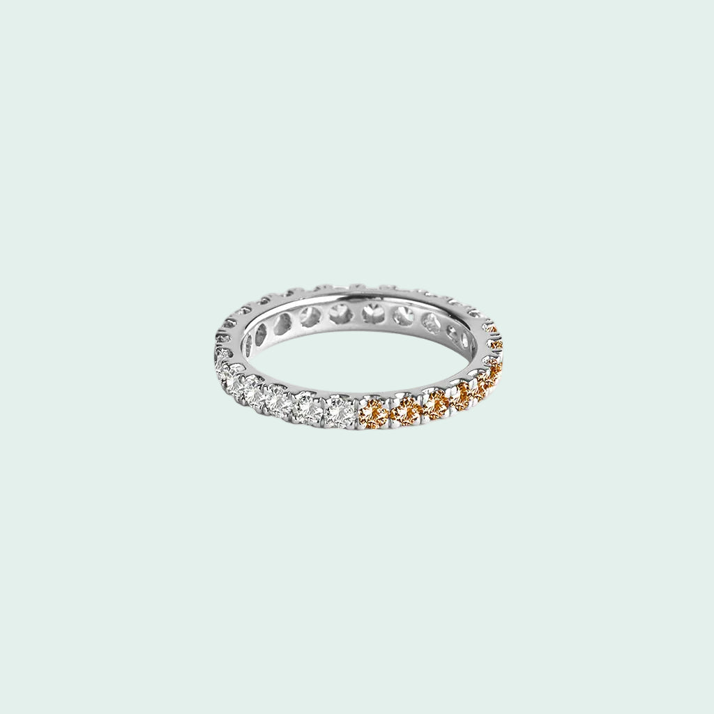 Silver ring with embedded diamonds and orange gemstones on a white background