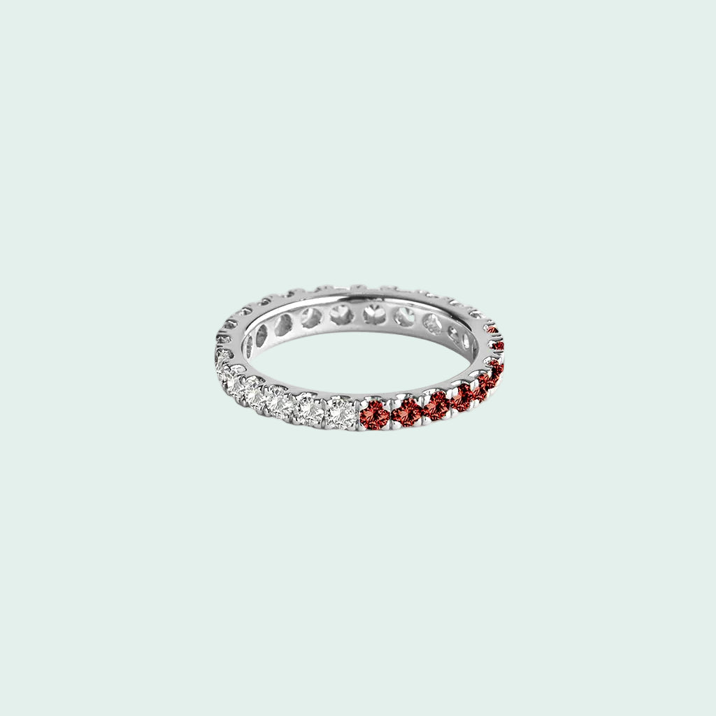 Silver ring with red and clear gemstones on a white background