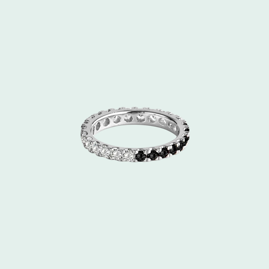 Eternity ring with black and white gemstones on a white background