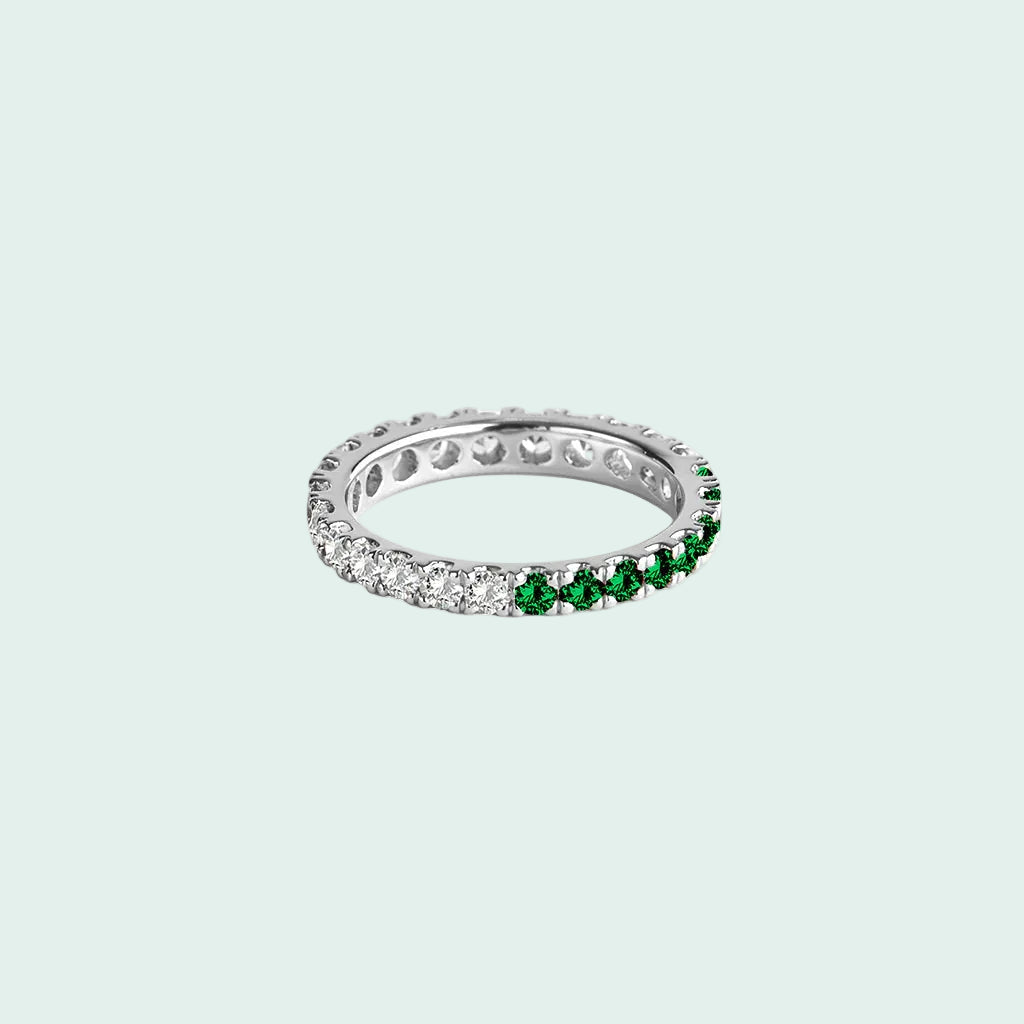 Silver ring with green gemstones on a white background