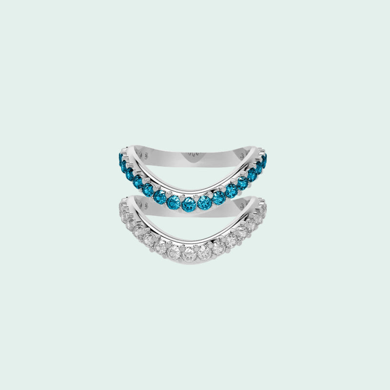Two silver rings with blue and clear gemstones on a white background