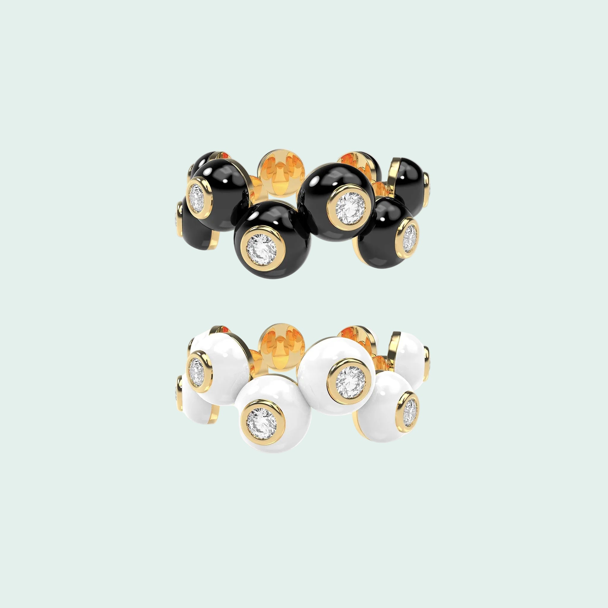 Two rings with black, gold, and white stones on a white background