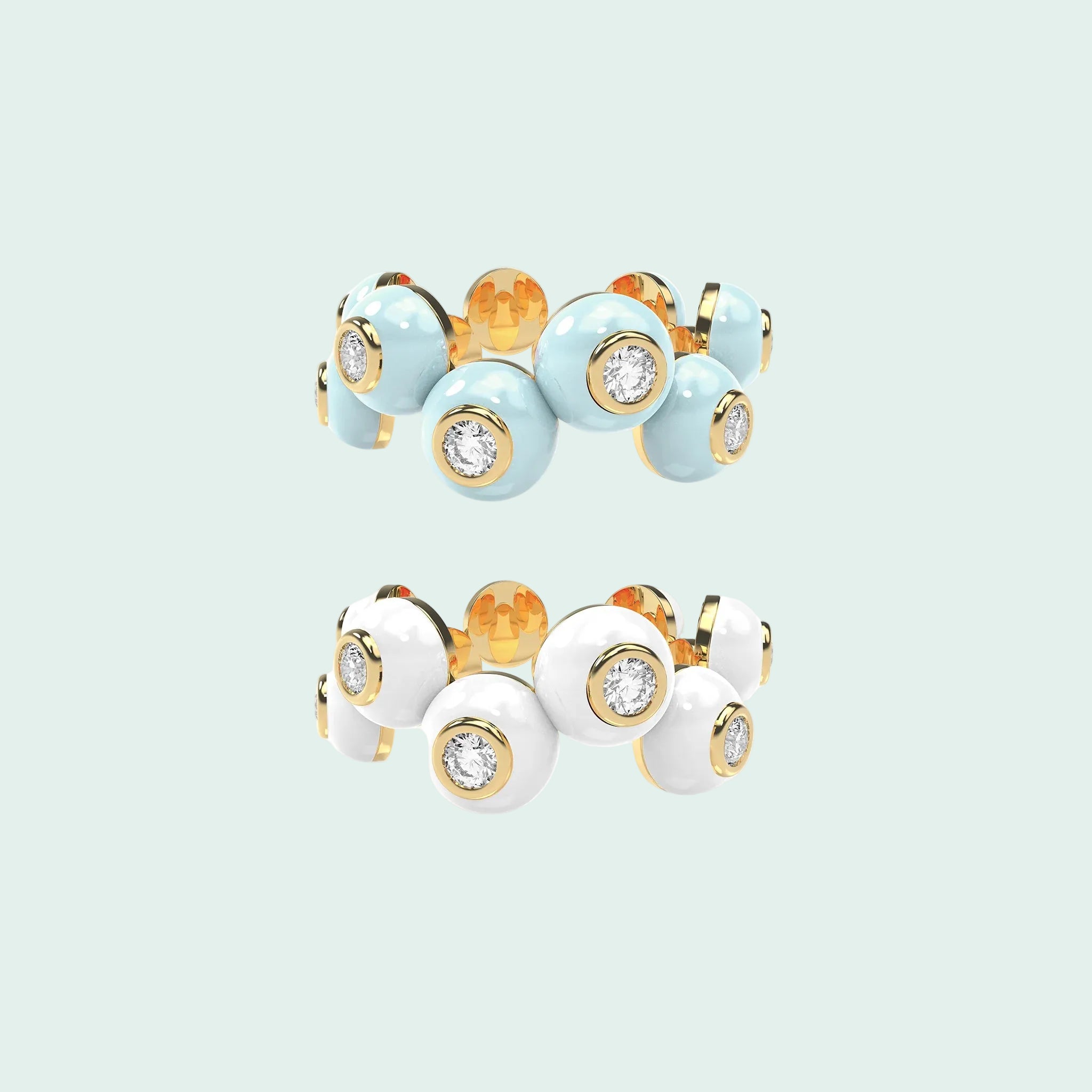 Two rings with gold, white, and light blue enamel design on a white background