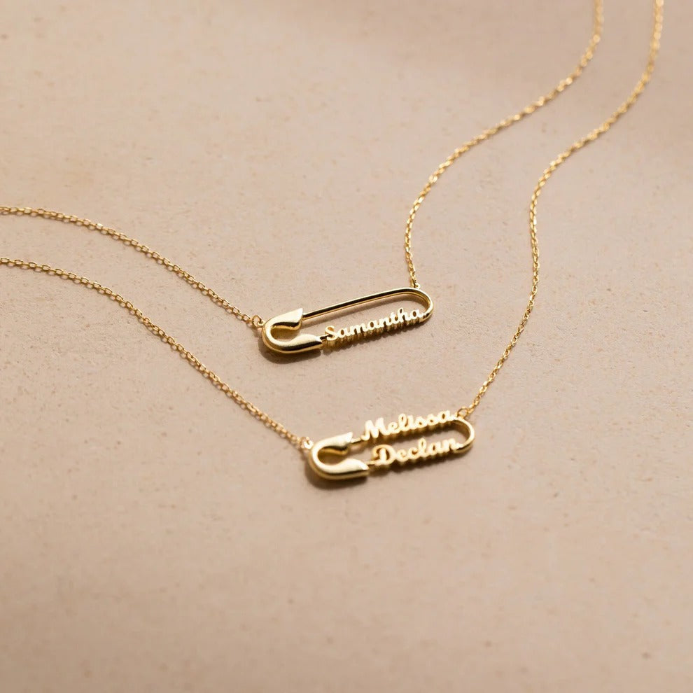 Gold necklaces with name pendants on a beige background