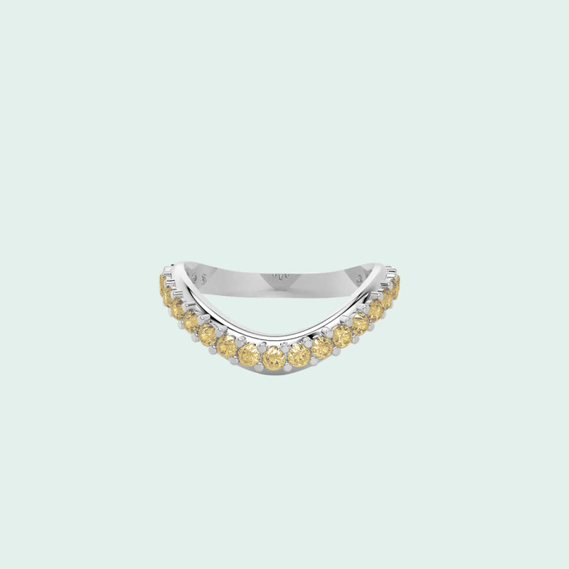 Silver ring with yellow gemstones on a white background