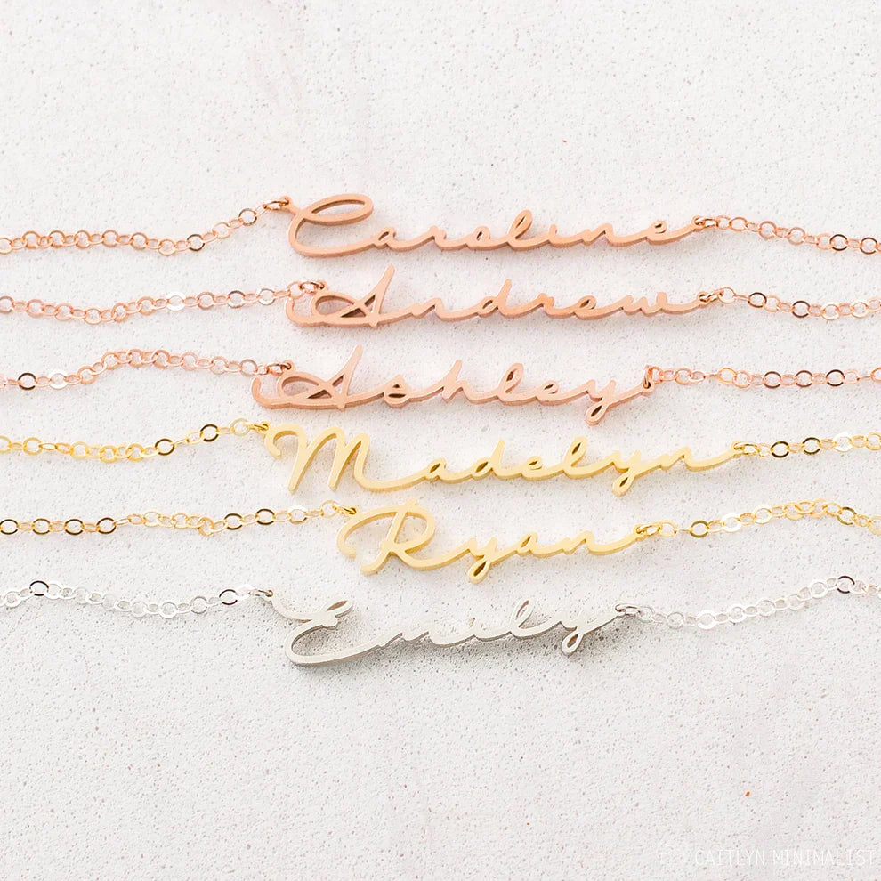 Set of gold name necklaces on a light background